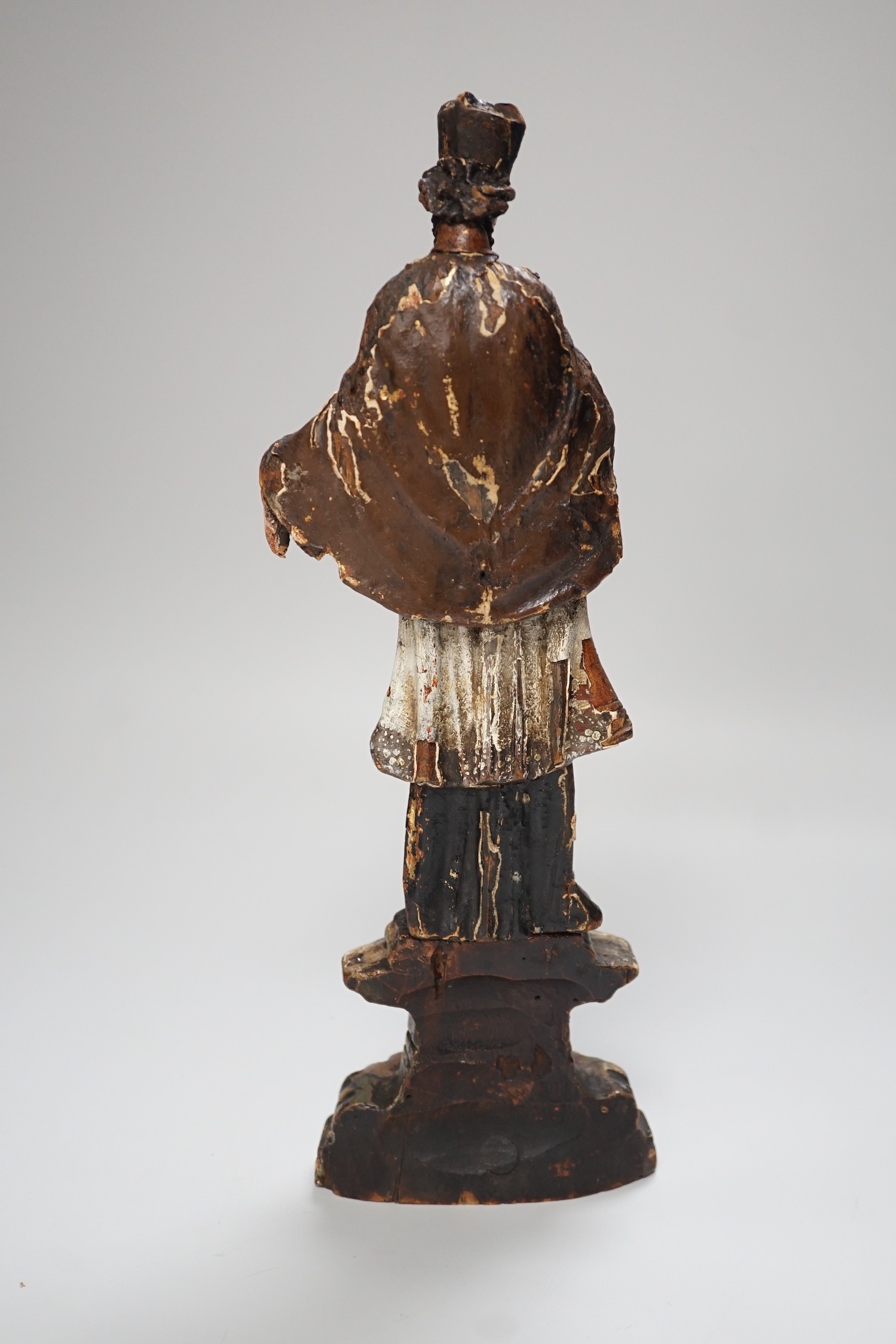 An 18th/19th century Continental carved wooden polychrome figure of saint, 33cms high